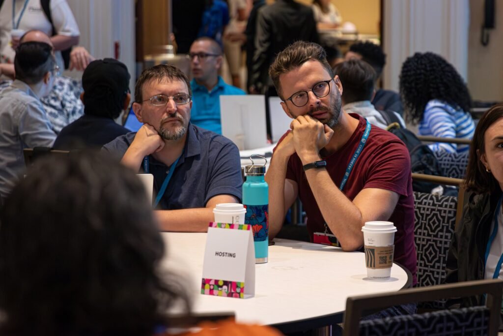 Marco Chiesi at a WordCamp table alongside a colleague